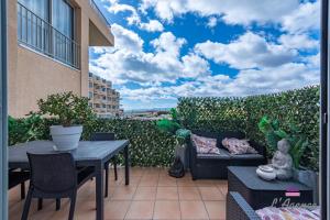 a patio with a couch and a table and chairs at Le Nid Cosy accès direct sur la mer in Le Barcarès
