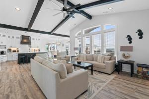 a living room with two couches and a kitchen at The Grand View 5bedrooms 5 Ba, Elevator, Heated Pool in Ocean Isle Beach