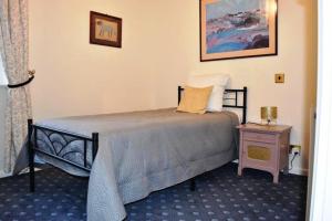a bedroom with a bed and a table with a lamp at Country House La Feronnière in Le Mesnil-Amand