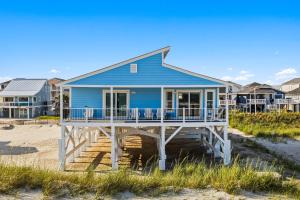 a blue house on the beach with houses at Ocean Front, Pet Friendly with AMAZING Views in Ocean Isle Beach in Ocean Isle Beach