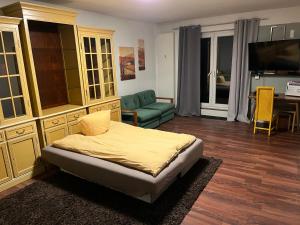 a bedroom with a bed and a couch and a television at Apartment Rainer mit großen Parkplätzen vorm Gebäude in Heddesheim