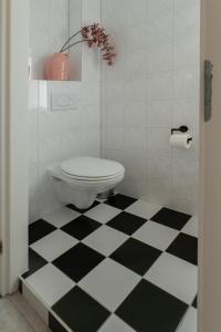 a bathroom with a toilet and a black and white checkered floor at Aan `t Krakeel in Noordscheschut +27 photos