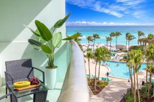 a balcony with a view of a pool and the ocean at Oceanview King Bed Right on the Beach w Pool&Gym in Hollywood