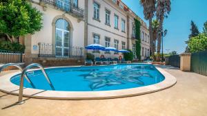 a swimming pool in front of a building at Hotel Sol e Serra in Castelo de Vide