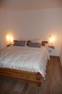 een slaapkamer met een groot wit bed met 2 lampen bij Cafcauter in Sint-Pieters-Kapelle