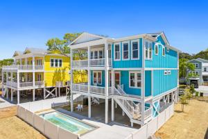 ein großes blaues Haus mit Pool in der Unterkunft NEW Orchards Ocean in Oak Island, Custom home with private heated pool in Oak Island