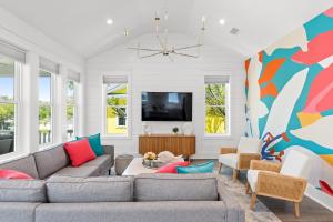 ein Wohnzimmer mit Couch und Fernseher in der Unterkunft NEW Orchards Ocean in Oak Island, Custom home with private heated pool in Oak Island
