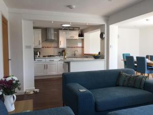 a living room with a blue couch and a kitchen at Maceley in Kingsbridge