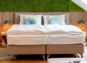 a large bed with white sheets and blue pillows at Ferienhof Taarstedt Mikkey in Taarstedt +3 photos
