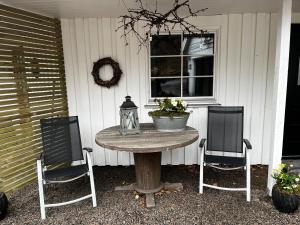 a table with two chairs and a vase on it at Seaside apartment at Holmen in Kristiansand
