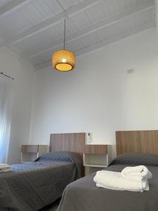 a bedroom with two beds and a light fixture at Anna Apart Boutique in Colón