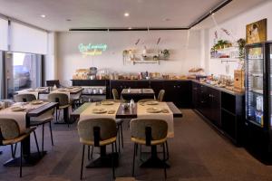 a restaurant with tables and chairs and a bar at Alpha Hotel and Aparthotel in Tienen