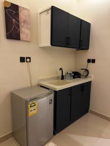 Una pequeña cocina con fregadero y refrigerador. en Luxury Apartment in Riyadh, en Riad