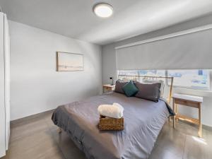 a bedroom with a bed with a table and a window at Aquabella 7 Paradise Stay in Isla Verde in San Juan +19 photos