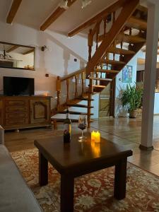 a living room with a wooden table and stairs at Casuta-Lacului in Unciuc