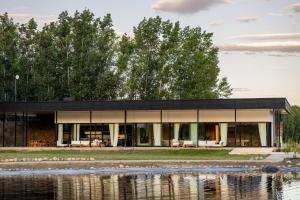 a house with a black roof next to a body of water at House by Casa Septem in Tupungato