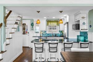 a kitchen with white cabinets and bar stools at Ocean Front 3 Bedroom 2 Bath Home, Pet Friendly in Ocean Isle Beach
