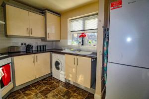 una cocina con refrigerador y lavadora y secadora en Ripley House by Smart Corporate Stays, en Ripley