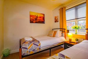 Un dormitorio con dos camas y una ventana. en Ripley House by Smart Corporate Stays, en Ripley