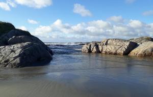 a beach with rocks in the water and the ocean at 4 Bedroom Cozy Home In Sirevåg in Sirevåg +11 photos