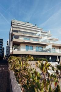 a large white building with trees in front of it at Vibra Tahiti Prestige in Lido di Jesolo