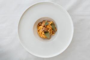 een witte plaat met een kom eten op een tafel bij Àlia Bianca Active & Family Hotel in Andalo