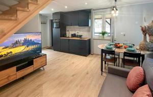 a living room with a large tv and a kitchen at 2 Bedroom Awesome Home In Ostroda in Ostróda