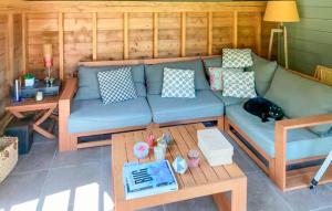 a living room with a blue couch and a table at Lovely Home In Canville Les Deux Égli in Canville-les-Deux-Églises +19 photos