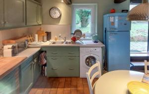 a kitchen with a sink and a washing machine at Lovely Home In Canville Les Deux Égli in Canville-les-Deux-Églises