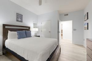 a white bedroom with a large bed with blue pillows at TOPS'L Tides 0207 in Destin +33 photos