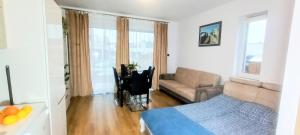Un dormitorio con una cama, un sofá y un escritorio. en Flamingo 20, en Międzyzdroje
