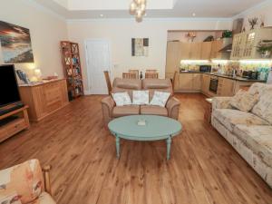a living room with a couch and a table at Apartment 7 Mansion House in Tenby