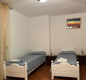 a bedroom with two beds and a picture on the wall at Stanze private in appartamento in Udine