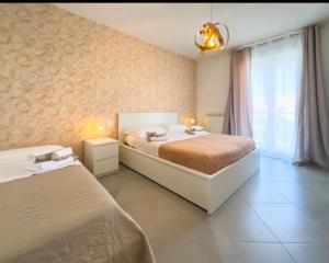 una camera da letto con due letti e una finestra di B&B ALLA NIVIERA ad Adelfia