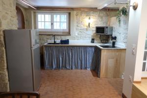 a kitchen with a refrigerator and a sink at Le moulin de Masseilles in Mazères