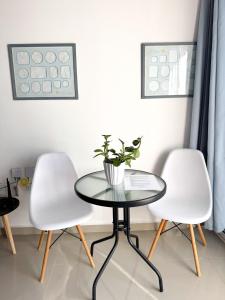 two white chairs and a glass table with a plant on it at Vista al Mar in Pampatar