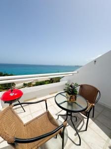 a balcony with a table and chairs and a view of the ocean at Vista al Mar in Pampatar +15 photos