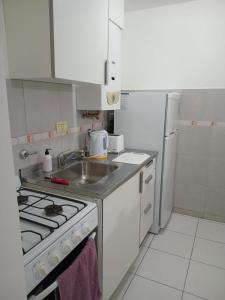 a kitchen with a stove and a sink and a refrigerator at Centro de Paraná - 1 Dormitorio !!! in Paraná