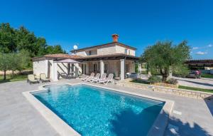 a swimming pool in front of a house at Villa Mali Raj in Žikovići