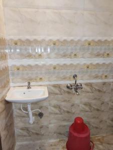 Un baño con un lavabo y un recipiente rojo. en Saidham Comfort, en Bangalore