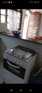 a stove top oven sitting in a kitchen at Casa de praia Mongaguá in Mongaguá +6 photos
