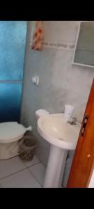 a bathroom with a toilet and a sink at Casa de praia Mongaguá in Mongaguá