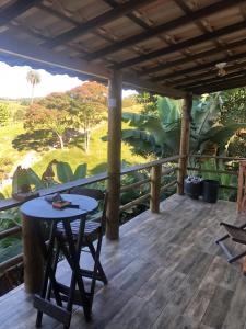 un patio con tavolo e sedie su un ponte di Altamira Cachoeiras a União de Caeté