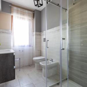 a bathroom with a shower and a toilet and a sink at Casa Libeccio in Quartu SantʼElena