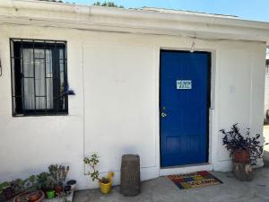 a blue door on a white house with a sign on it at Rincon de Las Condes in Santiago