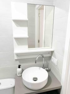 a white bathroom with a sink and a mirror at Estudio 2 Minutos De La Playa in Portonovo