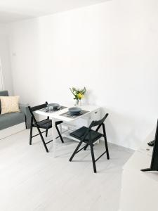 a white living room with a white table and chairs at Estudio 2 Minutos De La Playa in Portonovo +3 photos