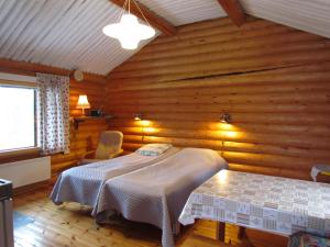 a bedroom with two beds in a wooden room at Ukonloma Aimola in Rovaniemi