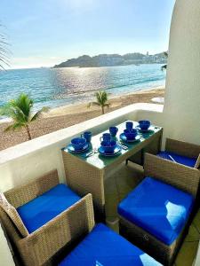 a table and chairs on a balcony with a view of the beach at Espectacular Apto a pie de Playa con vista al mar in Manzanillo