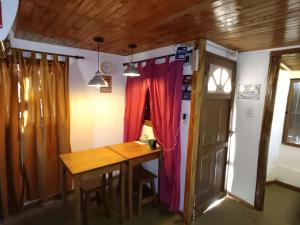a dining room with a table and a red curtain at Mar del Plata- Playa Chapadmalal- Finca Viento Norte UNA CABAÑA HASTA 5 HUESPEDES Y UN DORMI CON BAÑO PRIVADO ATRAS HASTA 2 HUESPEDES in Chapadmalal